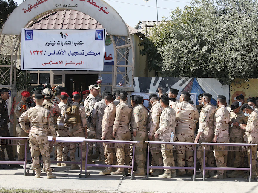 قوات أمنية عراقية أمام مركز اقتراع بمدينة الموصل ينتظرون الإدلاء بأصواتهم في الانتخابات - 8 أكتوبر 2021 - "الشرق"