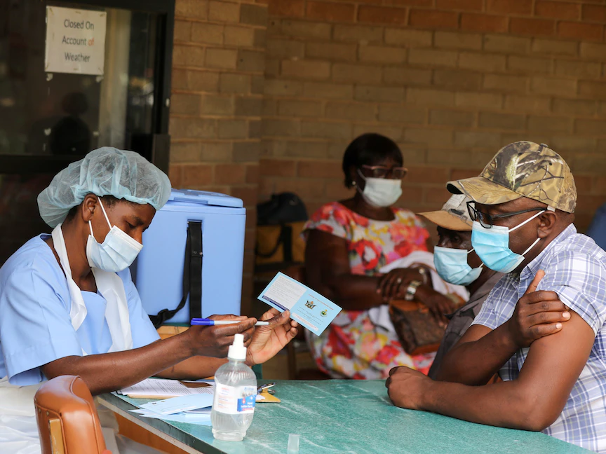 رجل يتسلم شهادة تطعيم بعد تلقيه اللقاح المضاد لفيروس كورونا في مستشفى ويلكينز، هراري، زيمبابوي - 24 مارس 2021. - REUTERS