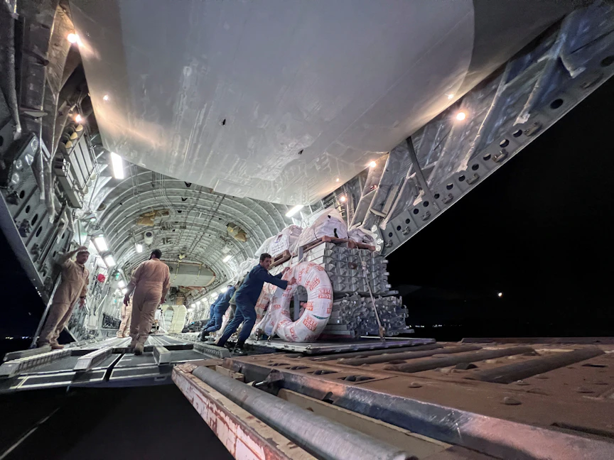 عمال يفرغون مواد إغاثة من طائرة شحن عسكرية قادمة من قطر لتقديم الدعم على الأرض في مطار بنينا الدولي، بنغازي، ليبيا. 13 سبتمبر 2023 - REUTERS