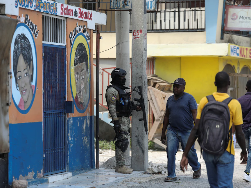 أحد أفراد الشرطة الوطنية الهايتية يقوم بدورية راجلة في أحد الشوارع، حيث أجبرت المعارك المستمرة بالأسلحة النارية بين العصابات المتناحرة السكان على الفرار من منازلهم في بورت-أو-برنس عاصمة هايتي - 28 أبريل 2022 - REUTERS