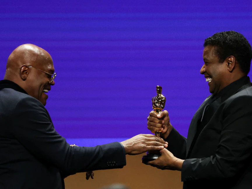 دنزل واشنطن يسلم صامويل جاكسون جائزة "أوسكار" الفخرية خلال حفل توزيع جوائز المحافظين الـ12 في قاعة راي دولبي، لوس أنجلوس- 25 مارس 2022 - REUTERS