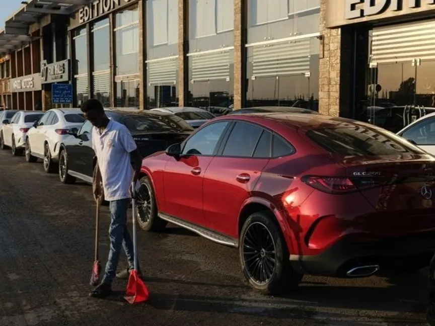 عامل ينظف الطريق خارج صالة عرض سيارات جديدة في منطقة مصر الجديدة بالقاهرة - bloomberg