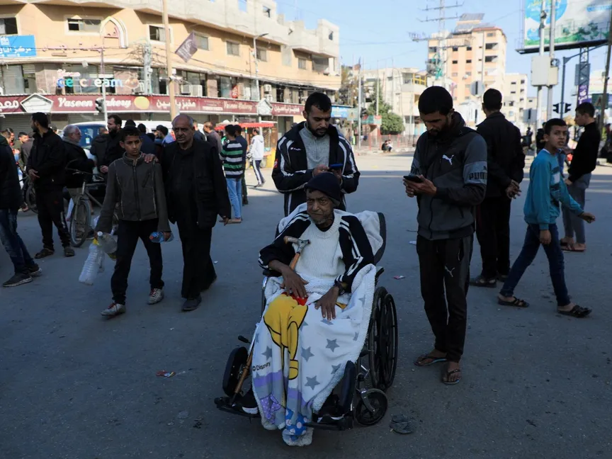 رجل على كرسي متحرك بينما يفر الفلسطينيون من منازلهم بعد أن أمرهم الجيش الإسرائيلي بإخلاء مخيم البريج في وسط قطاع غزة. 26 ديسمبر 2023 - Reuters