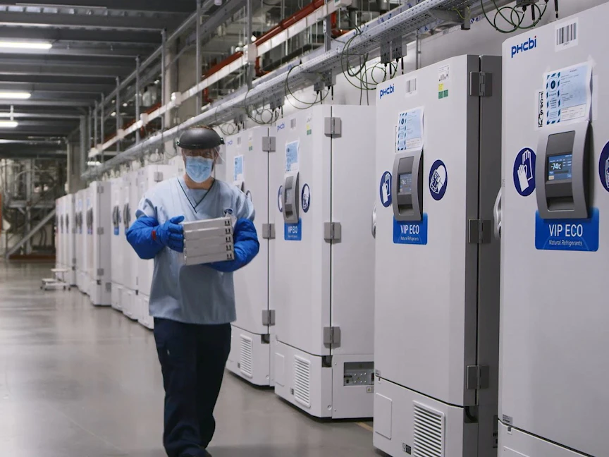 أحد العاملين في شركة "فايزر" ينقل اللقاح إلى إحدى ثلاجات الحفظ - REUTERS