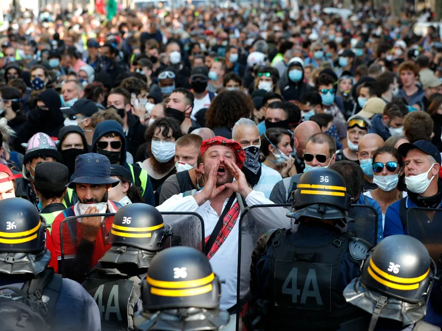 متظاهر يقف بمواجهة الشرطة في باريس ويهتف بشعارات مناهضة للحكومة - 12 سبتمبر 2020 - AFP