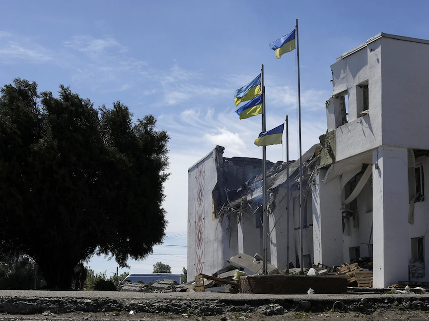 أعلام أوكرانية أعلى دار الثقافة في ديرهاتشي والتي كانت تستخدم لتوزيع المساعدات بعد أن أصابها قصف روسي بالقرب من خاركيف- 13 مايو 2022 - REUTERS