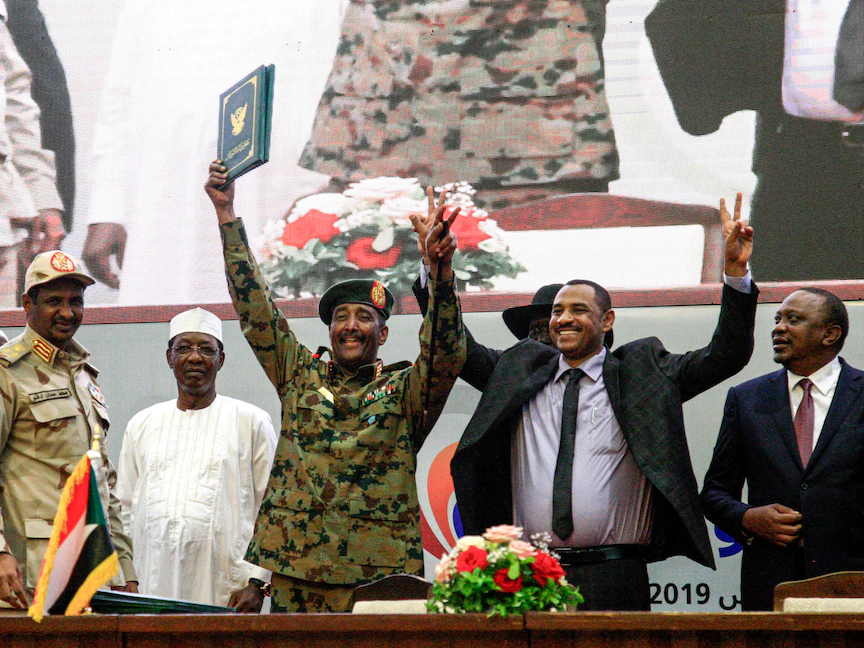 المفوض باسم قوى الحرية والتغيير أحمد ربيع إلى جانب اللواء عبد الفتاح البرهان، رئيس المجلس العسكري الانتقالي الحاكم خلال احتفال توقيع "الوثيقة الدستورية" - 17 أغسطس 2019 - AFP