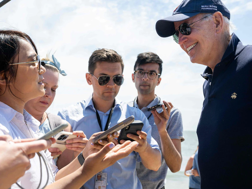 الرئيس الأميركي جو بايدن يتحدث مع الصحافيين أثناء سيره على الشاطئ ريهوبوث بولاية ديلاوير - 20 يونيو 2022 - AFP