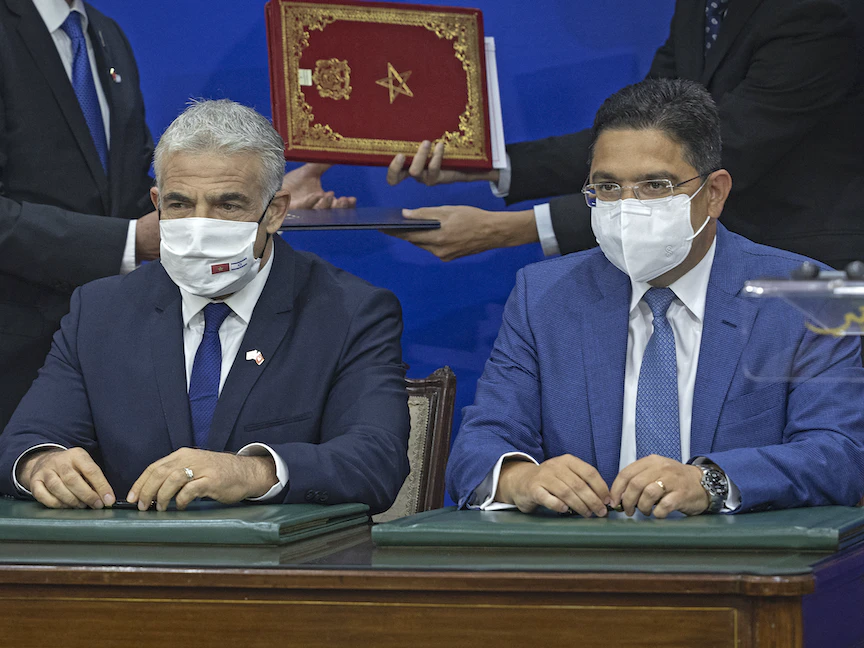 وزير الخارجية المغربي ناصر بوريطة (يمين) إلى جانب نظيره الإسرائيلي يائير لبيد بعد توقيع اتفاقيات في الرباط، 11 أغسطس 2021 - AFP