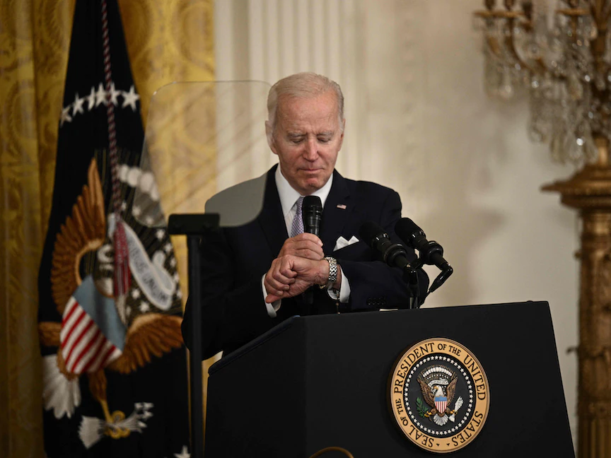 الرئيس الأميركي جو بايدن يتحقق من ساعته وهو يتحدث خلال حفل استقبال للاحتفال بعيد الفطرفي البيت الأبيض، واشنطن. 1 مايو 2023 - AFP