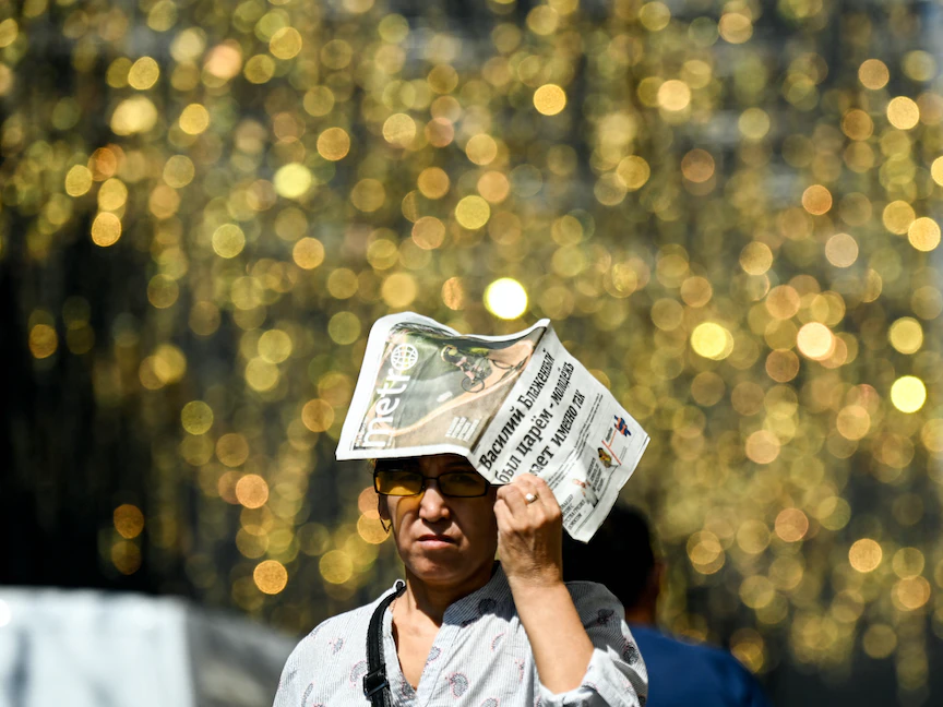 امرأة روسية تحمي نفسها من أشعة الشمس خلال يوم صيفي حار في وسط العاصمة موسكو. 13 يوليو 2021 - AFP