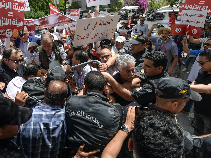 محتجون معارضون لقرارات الرئيس التونسي قيس سعيد يحاولون الوصول إلى مقر الهيئة العليا المستقلة للانتخابات - 04 يونيو 2022 - AFP