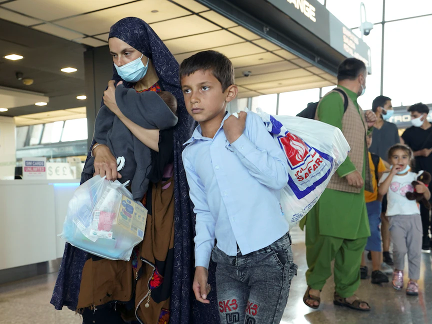 أفغان يتوجهون إلى مركز للتعامل مع طلبات اللاجئين بعد وصولهم إلى مطار دالاس - 24 أغسطس 2021 - REUTERS