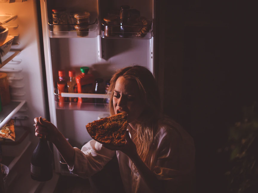 إمرأة مصابة باضطراب غذائي وتتناول الطعام في وقت متأخر - Getty Images