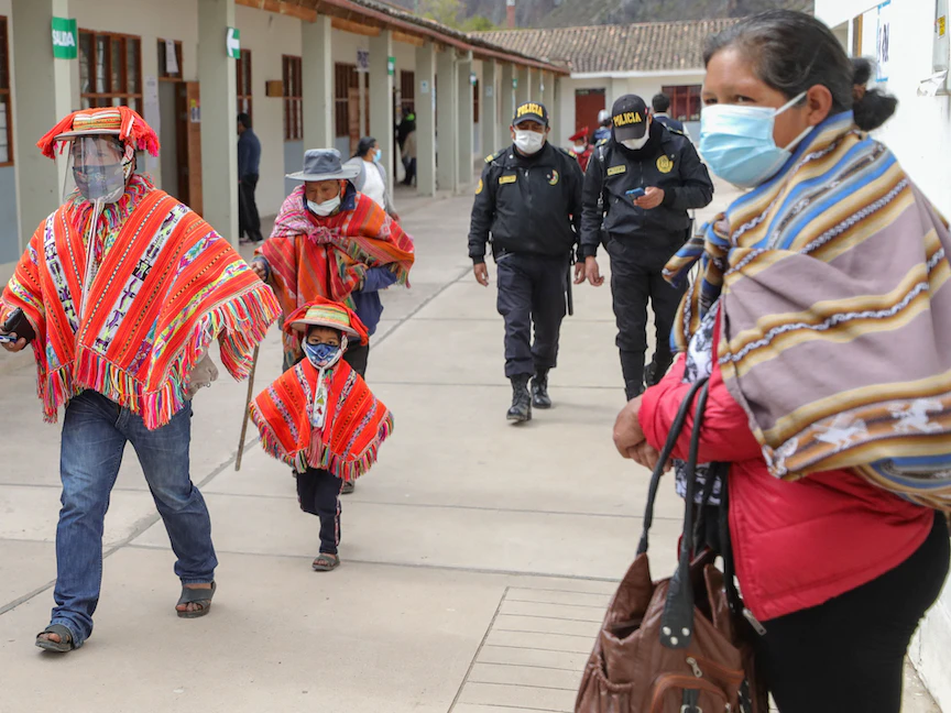 أشخاص يرتدون الزي الرسمي لبيرو يتجهون إلى مركز اقتراع للادلاء بأصواتهم في مجتمع الأنديز بالقرب من كوسكو ببيرو - 6 يونيو 2021 - AFP
