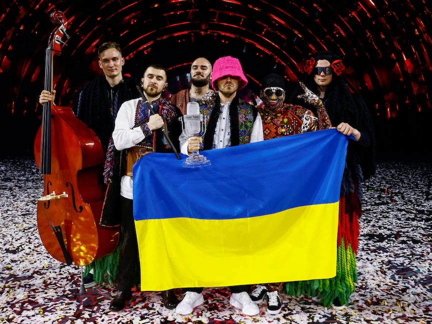 أعضاء فرقة "أوركسترا كالوش" يرفعون علماً أوكرانياً بعد فوزهم في مسابقة "يوروفيجن" للأغاني الأوروبية في تورينو - 15 مايو 2022 - REUTERS