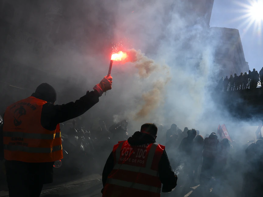 أحد المتظاهرين يحمل شعلة خلال مسيرة دعت إليها النقابات العمالية الفرنسية ضد خطة الحكومة لإصلاح نظام التقاعد في مارسيليا- 19 يناير 2023. - AFP