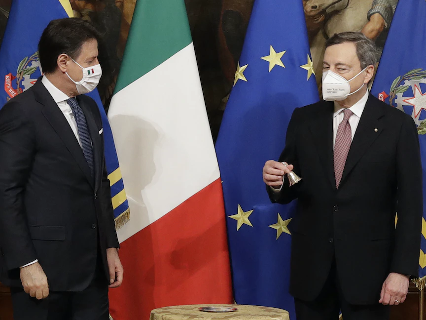 رئيس الوزراء الإيطالي الجديد ماريو دراغي (يمين) يحمل "جرس رئيس الحكومة" بينما ينظر إليه سلفه المنتهية ولايته جوزيبي كونتي خلال حفل التنصيب في روما - 13 فبراير 2021 - AFP