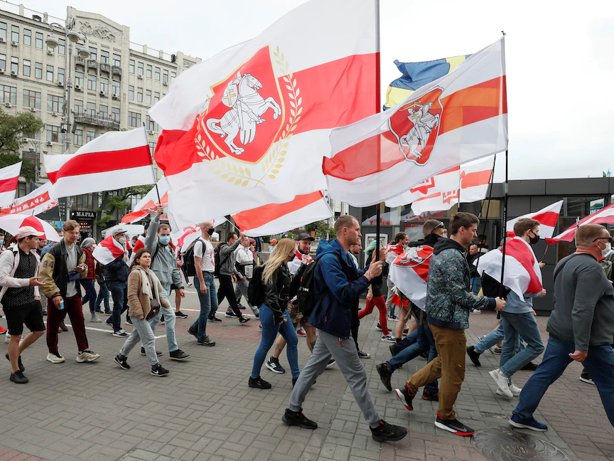 نشطاء يحملون أعلاماً تاريخية لبيلاروسيا وهم يسيرون خلال مسيرة لدعم الحركة البيلاروسية المناهضة للحكومة والمدون المعتقل رومان بروتاسيفيتش، في كييف، أوكرانيا. 30 مايو 2021 - REUTERS