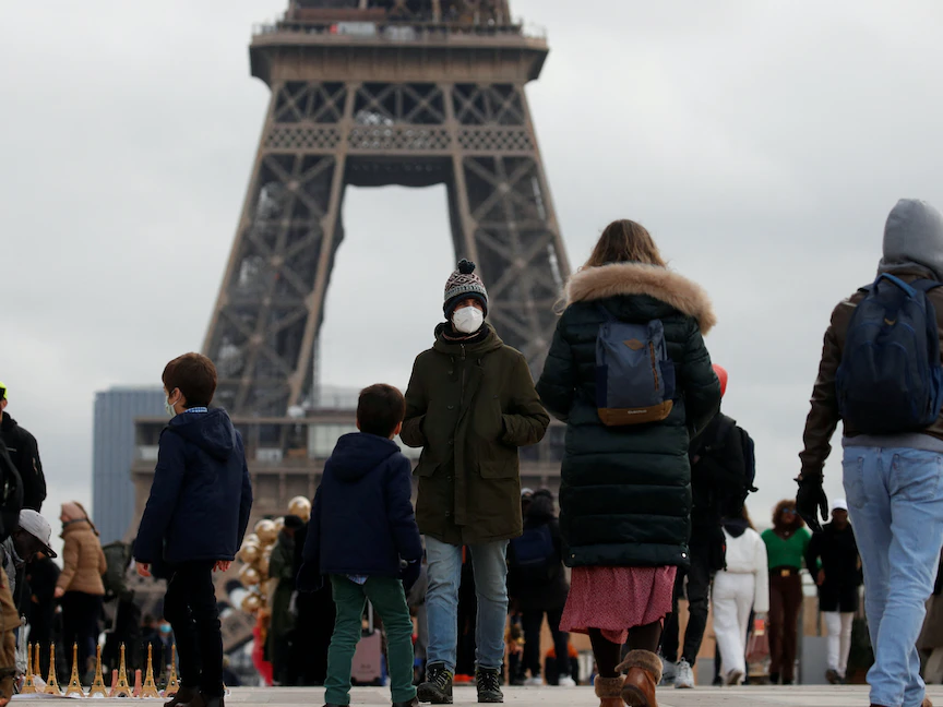 أشخاص يرتدون كمامات في ميدان تروكاديرو قرب برج إيفل في العاصمة الفرنسية باريس - 6 ديسمبر 2021 - REUTERS