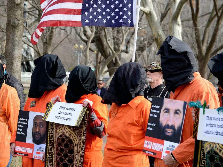 نشطاء يرتدون زي السجناء في مظاهرة تطالب بإغلاق معتقل غوانتانامو ومحاسبة المتورطين في التعذيب، واشنطن، 11 يناير 2020 - REUTERS