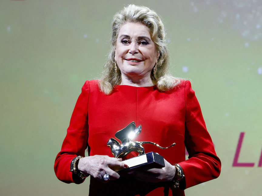 الممثلة الفرنسية كاترين دينوف تحمل جائزة الأسد الذهبي لإنجاز العمر. 31 أغسطس 2022 - REUTERS
