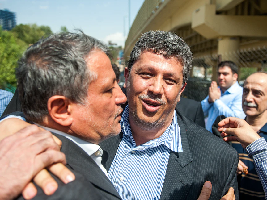 مهدي هاشمي رفسنجاني (وسط)، نجل الرئيس الإيراني السابق أكبر هاشمي رفسنجاني، يعانقه شقيقه محسن (يساراً) خارج سجن إيفين بطهران- 9 أغسطس 2015 - AFP