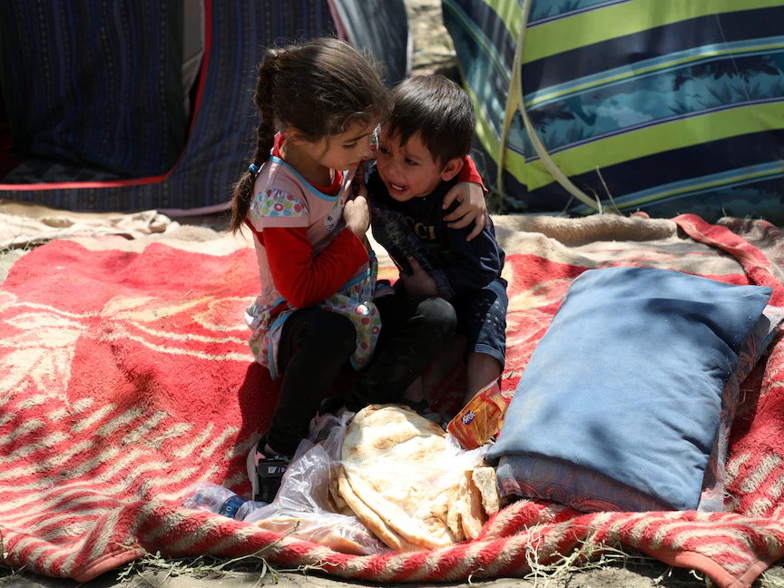 طفلة أفغانية تعانق شقيقها الخائف بعد فرار عائلتهما إلى العاصمة كابول هرباً من المقاطعات الشمالية حيث تقاتل "طالبان" القوات الحكومية - 10 أغسطس 2021 - REUTERS