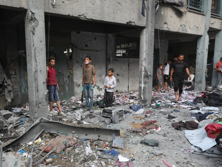 فلسطينيون يتفقدون الأضرار التي لحقت بمدرسة تابعة للأونروا تؤوي نازحين بعدما قصفتها غارة جوية إسرائيلية في مدينة غزة. 30 يونيو 2025 - REUTERS