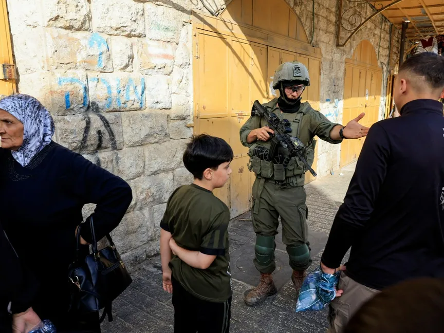 جندي إسرائيلي يمنع فلسطينيين من المرور في الخليل، بالضفة الغربية المحتلة، 25 يوليو 2026 - Reuters