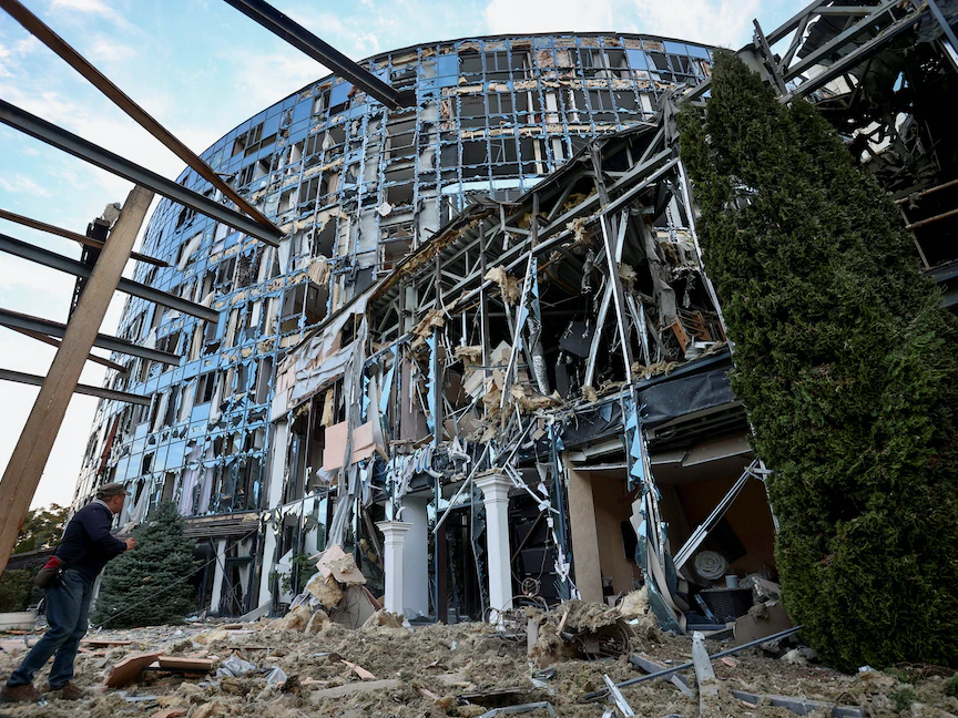 رجل يقف جوار مركز تجاري متضرر في منطقة خاركوف الأوكرانية، 9 سبتمبر 2022. - REUTERS