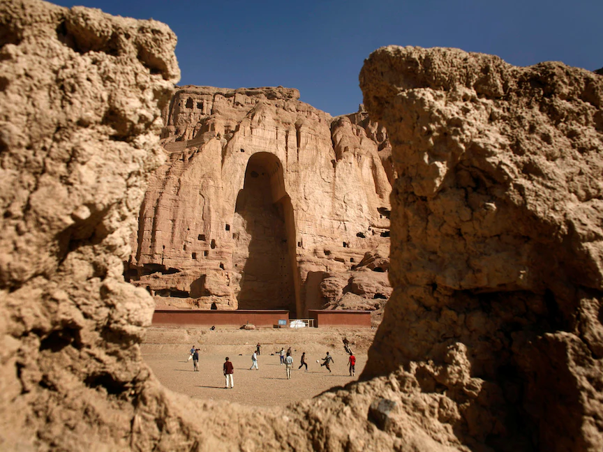 أولاد أفغان يلعبون كرة القدم أمام الكوة الفاصلة حيث كان تمثال بوذا العملاق يقف في مدينة باميان وسط البلاد، أفغانستان، 13 أبريل 2007. - REUTERS