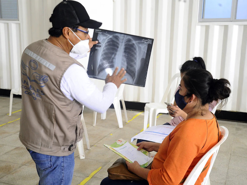 طبيب يشرح صورة الأشعة السينية لرئتي مريض - AFP