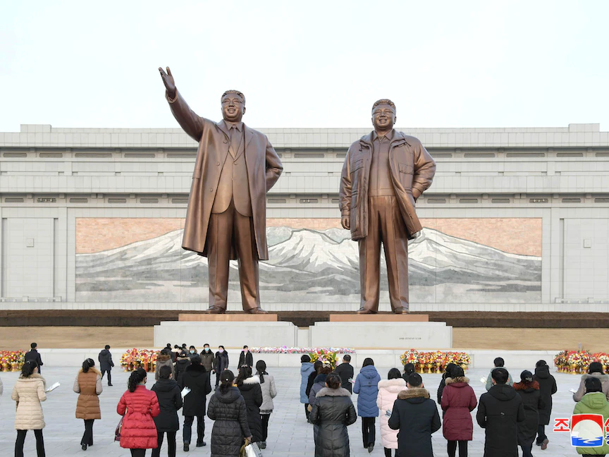 كوريون شماليون يضعون أزهاراً أمام تمثالين من البرونز للزعيمين الراحلين كيم إيل سونغ وكيم جونغ إيل في احتفال يوم النجمة الساطعة في بيونغ يانغ، كوريا الشمالية، 17 فبراير 2021 - REUTERS