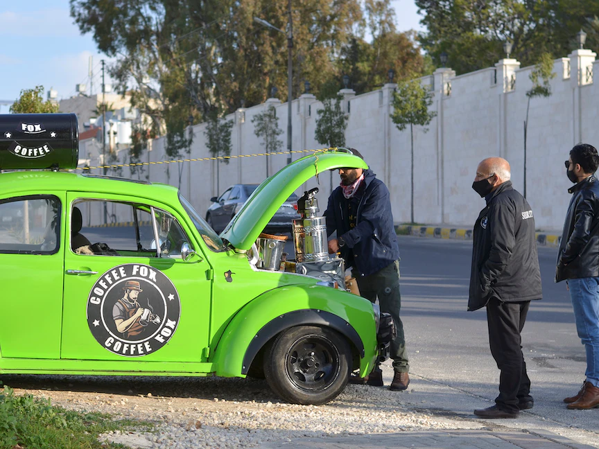 يقوم فادي أحمد بإعداد القهوة للعملاء في سيارته فولكس فاجن بيتل في عمان. - REUTERS