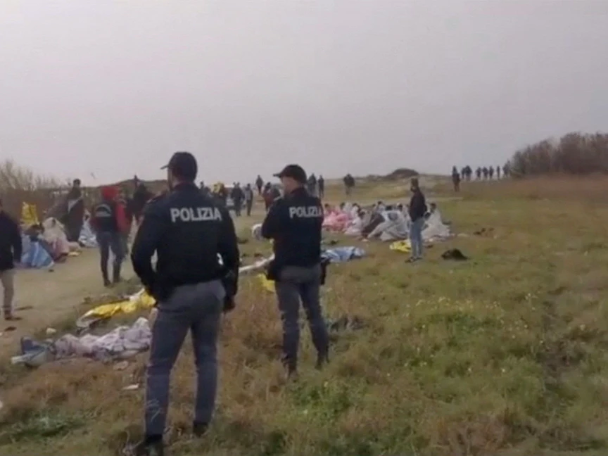 ضباط شرطة يقفون قرب الشاطئ خلال العثور على جثث المهاجرين قبالة مدينة كروتوني الإيطالية. 26 فبراير 2023 - REUTERS