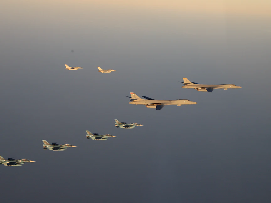 قاذفتان أميركيتان من طراز "B-1B" يرافقهما سرب مقاتلات تابع للقوات الجوية اليابانية فوق جزيرة كيوشو. 5 نوفمبر 2022 - REUTERS