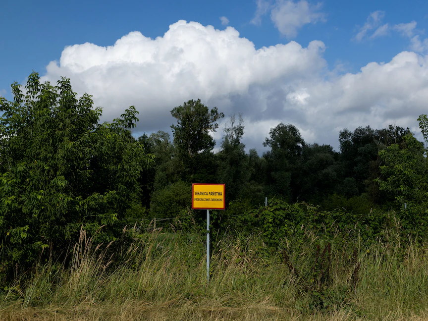 لافتة بالقرب من نهر بوغ على الحدود بين بولندا وبيلاروس بالقرب من كوستوملوتي كُتب عليها: "حدود الدولة. العبور محظور". 20 يوليو 2023 - REUTERS
