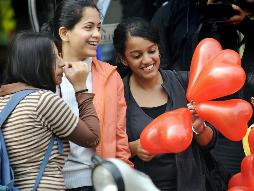 شابة هندية تمسك بالونات على شكل قلب في يوم الحب بالعاصمة نيودلهي. - AFP