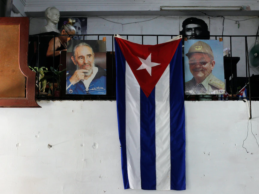 العلم الكوبي معلق بين صورتي الرئيس الكوبي الراحل فيدل كاسترو وشقيقه الرئيس السابق راؤول كاسترو في العاصمة هافانا - REUTERS