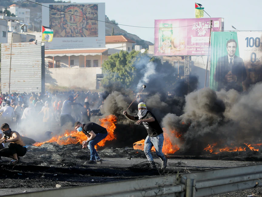 محتجون فلسطينيون ضد الاعتداءات الإسرائيلية في نابلس بالضفة الغربية. 18 مايو 2021. - REUTERS