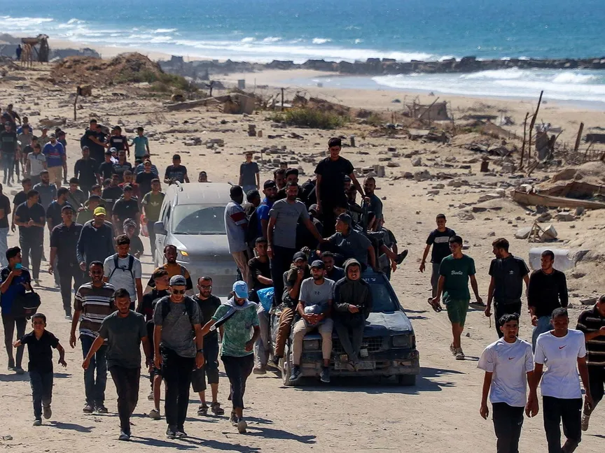 نازحون فلسطينيون يبدأون العودة إلى مدينة غزة عبر شارع الرشيد بعد دخول وقف النار حيز التنفيذ، 10 أكتوبر 2025 - REUTERS