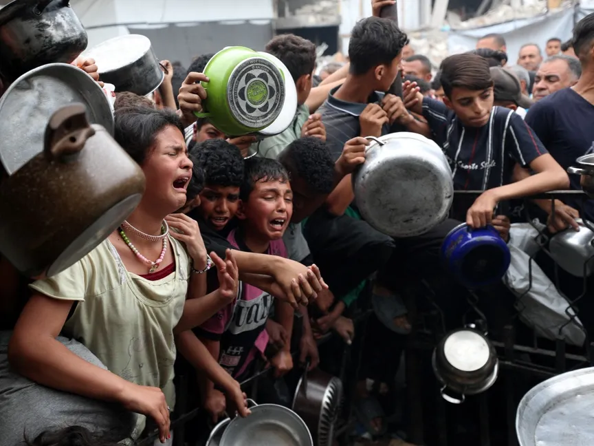 فلسطينيون ينتظرون الحصول على الطعام الذي أعدته جمعية خيرية في بيت لاهيا، شمال قطاع غزة، 24 أبريل 2025. - Reuters
