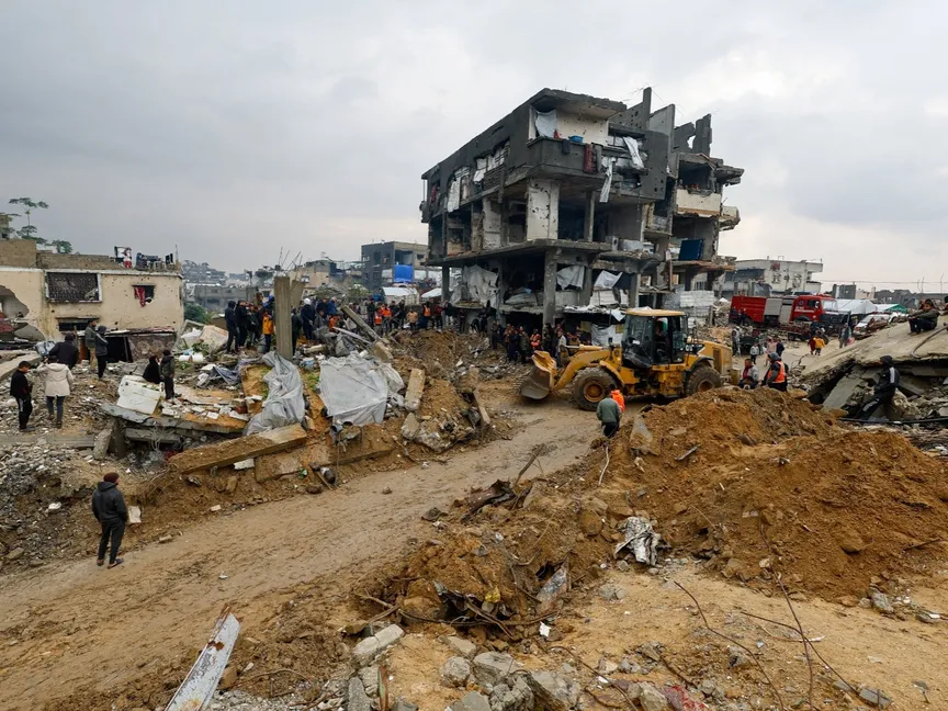 فلسطينيون يتجمعون حول مباني مدمرة في بيت لاهيا، شمال قطاع غزة. 12 ديسمبر 2025 - Reuters