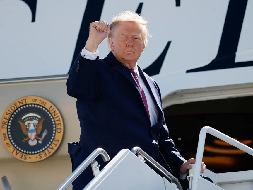 الرئيس الأميركي دونالد ترمب يرفع يده مقبوضة أثناء صعوده إلى طائرة 'Air Force One' في مطار هاري ريد الدولي بولاية نيفادا، قبل مغادرته إلى ولاية أريزونا. 14 أكتوبر 2026 - Reuters