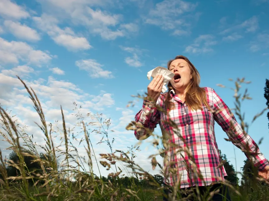 سيدة تعطس في مكان مفتوح - Getty Images