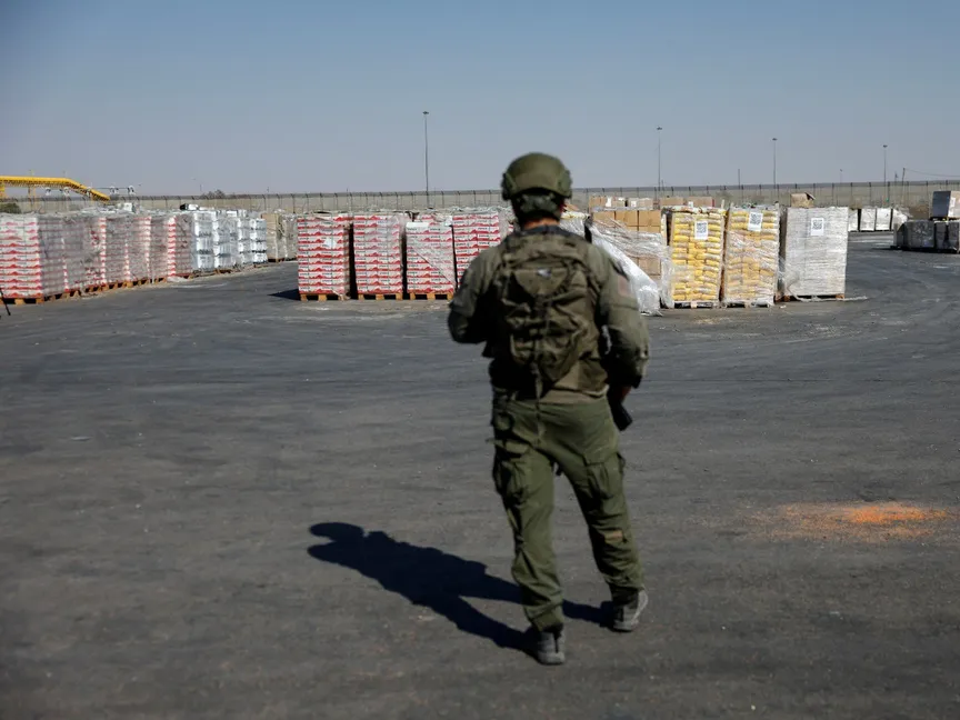 جندي إسرائيلي يقف بجوار المساعدات الإنسانية التي تنتظر نقلها إلى غزة في معبر كرم أبو سالم. 24 يوليو 2025 - Reuters