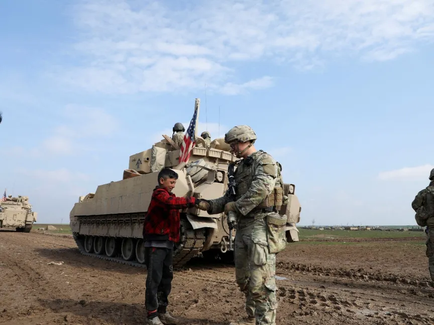 جندي أميركي يصافح شاب خلال دورية بريف القامشلي في شمال شرق سوريا. 8 فبراير 2024 - REUTERS