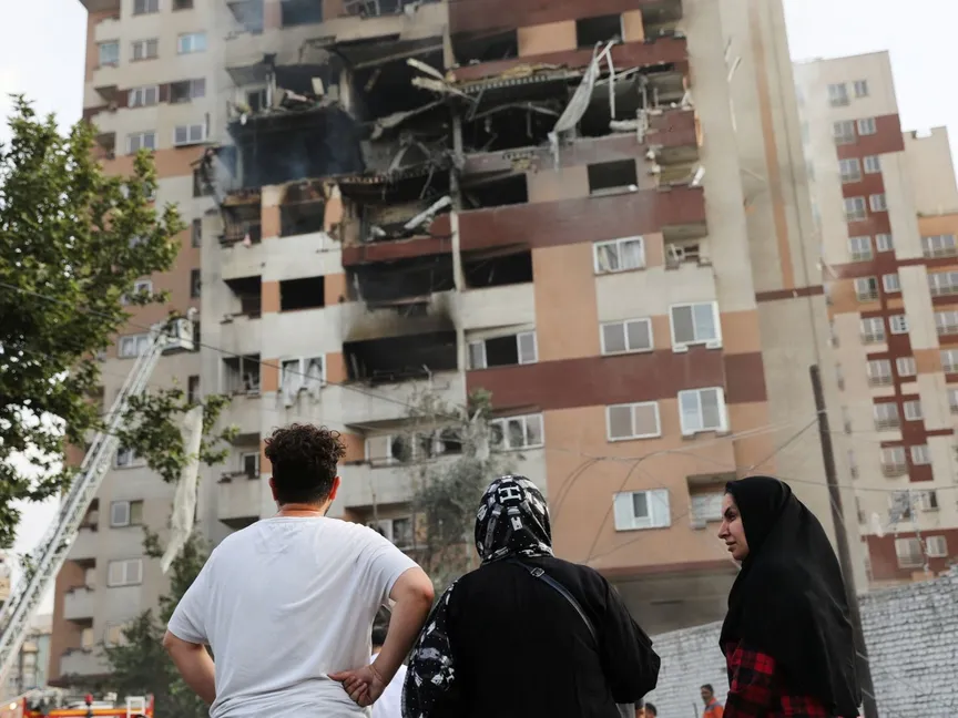 إيرانيون يتابعون آثار الدمار الناجم عن غارة إسرائيلية على مبنى سكني في طهران. 13 يونيو 2025 - via REUTERS