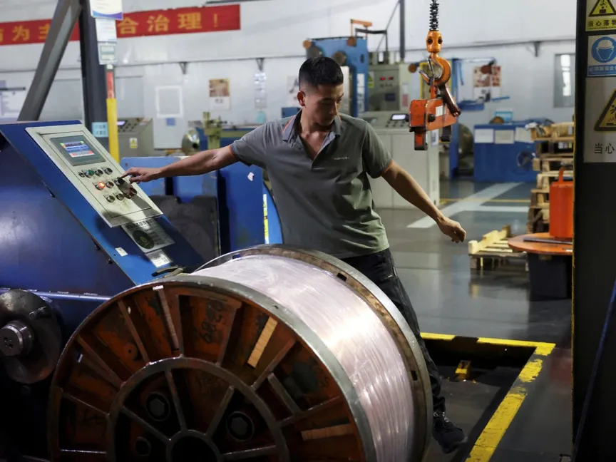 موظف يعمل بجوار بكرة من الأسلاك النحاسية المسطحة على خط إنتاج في أحد المصانع بمقاطعة جيانجشي الصينية. 14 أغسطس 2025 - Reuters